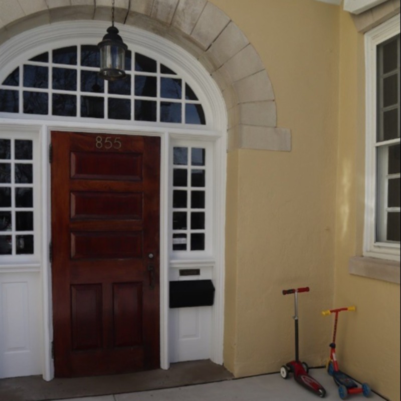 Front door of Meetinghouse with children's scooters parked beside it